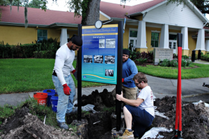 David Mourra, from left, Steve Harris and Greg Keller place African American Heritage Trail Board in front of the Carter G. Woodson African American History Museum. [Photo Courtesy of Melissa Lyttle of Tampa Bay Times]